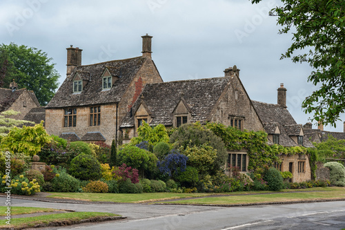 BROADWAY, ENGLAND - MAY, 27 2018: Thatched cottages with climbing plants in the village of Broadway, in the English county of Worcestershire, Cotswolds, UK 