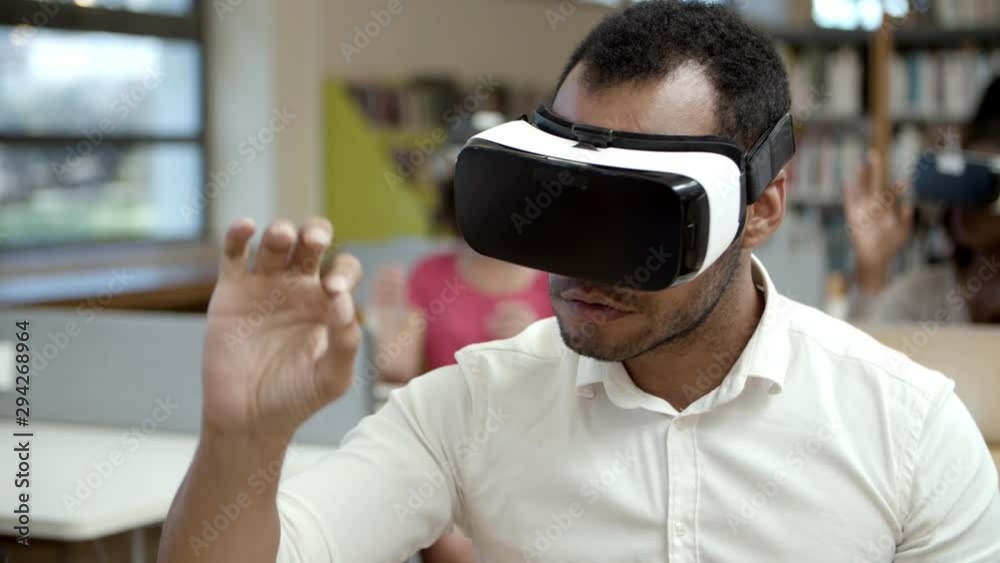 Slow motion shot of excited tester wearing VR headset. Concentrated African American man experiencing new VR glasses. Technology concept Slow motion shot of excited tester wearing VR headset. Concentrated African American man experiencing new VR glasses. Technology concept