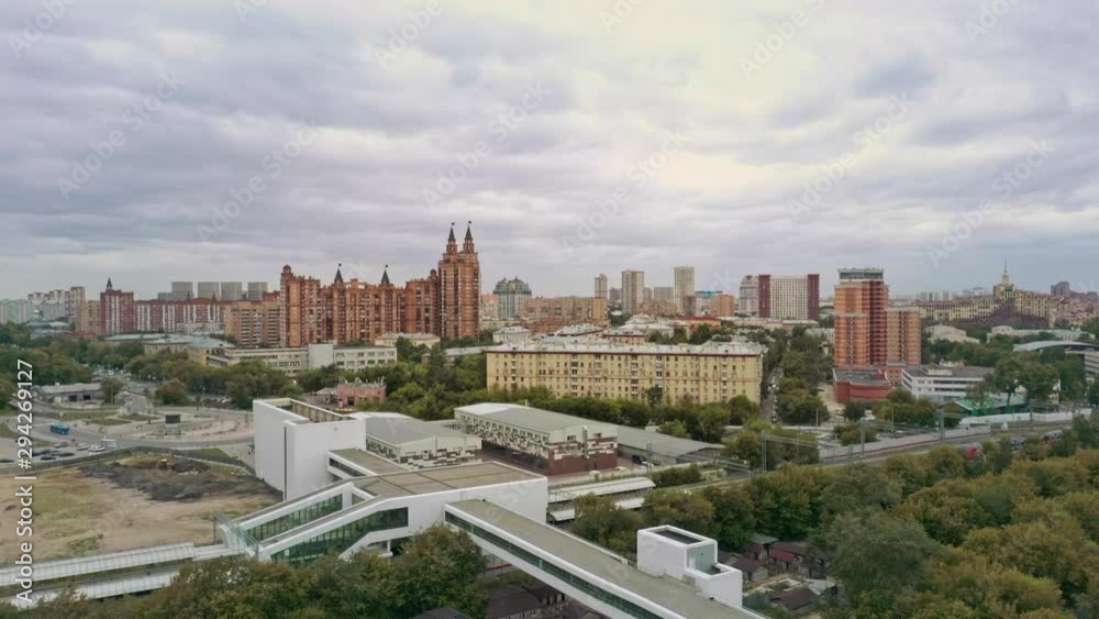 Aerial drone zoom fly over of railway road and houses on the horizon. City panoramic view of blocks of residential houses under cloudy sky Aerial drone zoom fly over of railway road and houses on the horizon. City panoramic view of blocks of residential houses under cloudy sky