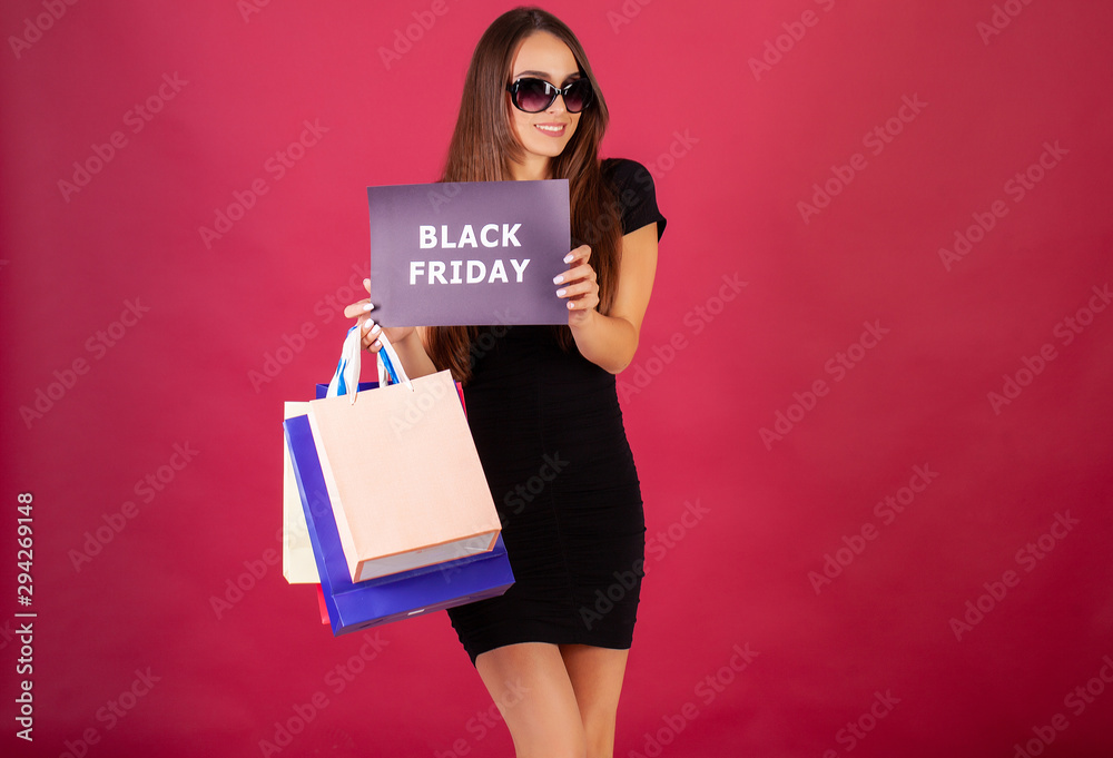 Black Friday. Woman with the inscription Black Friday and gift bags on a red background