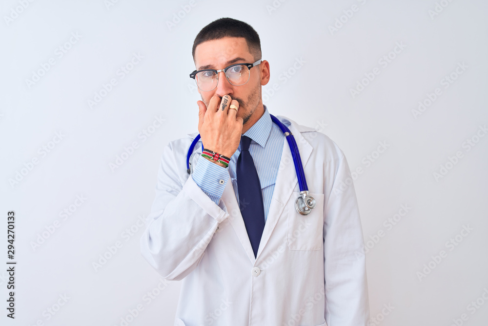 Young doctor man wearing stethoscope over isolated background looking stressed and nervous with hands on mouth biting nails. Anxiety problem. Young doctor man wearing stethoscope over isolated background looking stressed and nervous with hands on mouth biting nails. Anxiety problem.