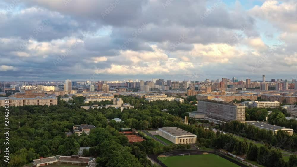 Aerial drone zoom in of Moscow suburban panorama wtih green forest park under cloudy sky. Moscow panorama of residential buildings in summer Aerial drone zoom in of Moscow suburban panorama wtih green forest park under cloudy sky. Moscow panorama of residential buildings in summer