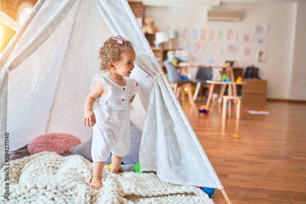Beautiful caucasian infant playing with toys at colorful playroom. Happy and playful with indian tent at kindergarten. Beautiful caucasian infant playing with toys at colorful playroom. Happy and playful with indian tent at kindergarten.