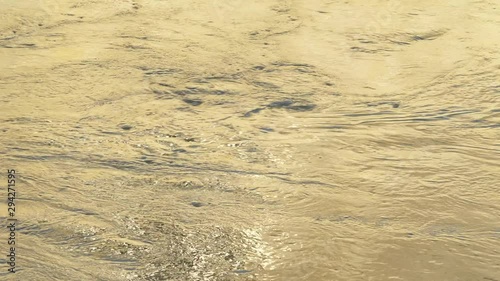 Fast moving river in gold hour close up abstract background 