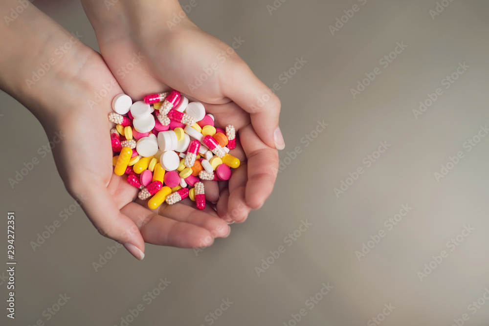 a handful of tablets of different colors in female hands a handful of tablets of different colors in female hands