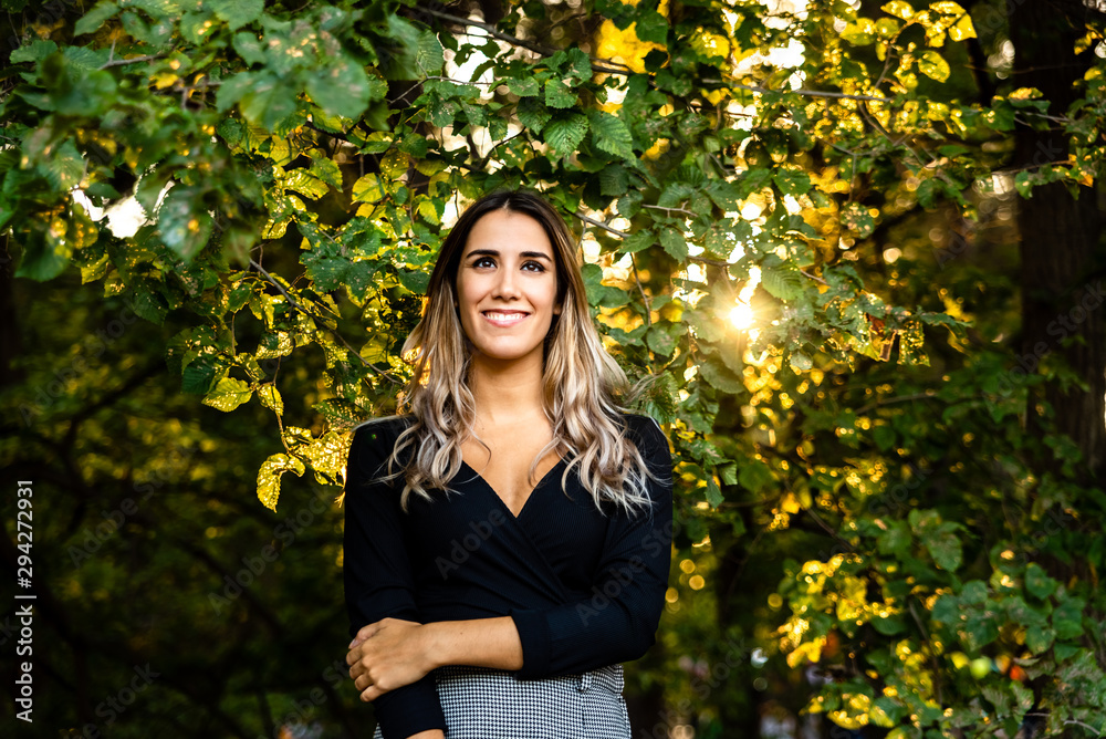 Young 20 year old woman posing attractively with a lovely charming smile in nature. Young 20 year old woman posing attractively with a lovely charming smile in nature.