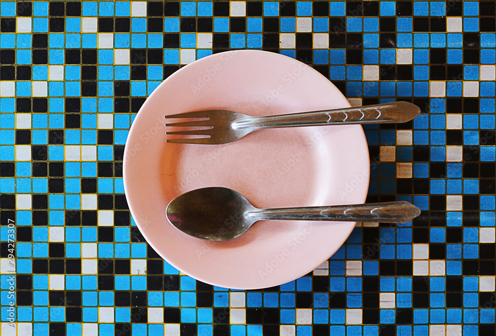 Empty plate on wooden table with fork and spoon Empty plate on wooden table with fork and spoon
