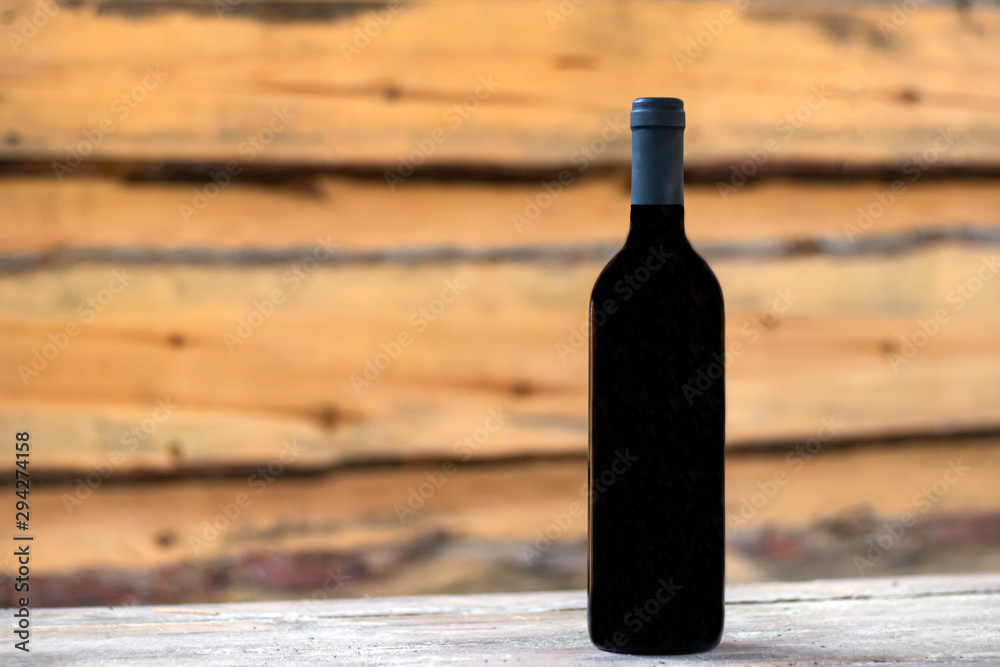 A bottle of red wine on the background of boards. A bottle of red wine on the background of boards.