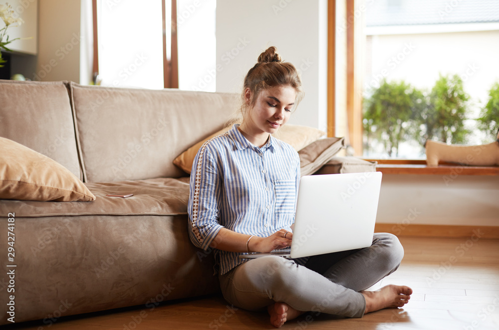 Happy woman with laptop on living room floor Happy woman with laptop on living room floor