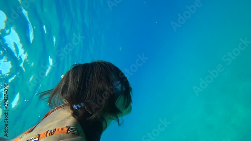 Kastellorizo, Greek island - 1st of October 2019: 4K Free diving woman tumbles in the turquoise sea photo