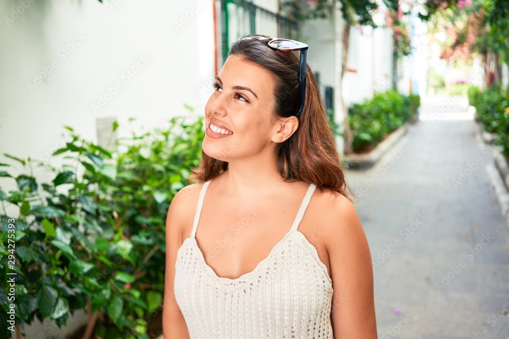 Young beautiful woman at the colorful village of Puerto de Mogan, smiling happy at the street on summer holidays Young beautiful woman at the colorful village of Puerto de Mogan, smiling happy at the street on summer holidays