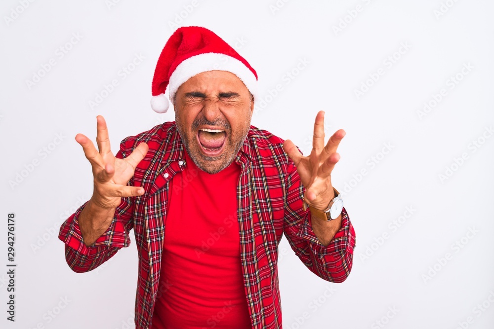Middle age man wearing Christmas Santa hat standing over isolated white background celebrating mad and crazy for success with arms raised and closed eyes screaming excited. Winner concept Middle age man wearing Christmas Santa hat standing over isolated white background celebrating mad and crazy for success with arms raised and closed eyes screaming excited. Winner concept