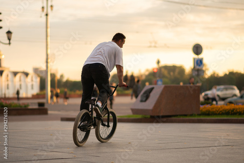 Fototapeta Naklejka Na Ścianę i Meble -  The guy rides a BMX bike down the street.