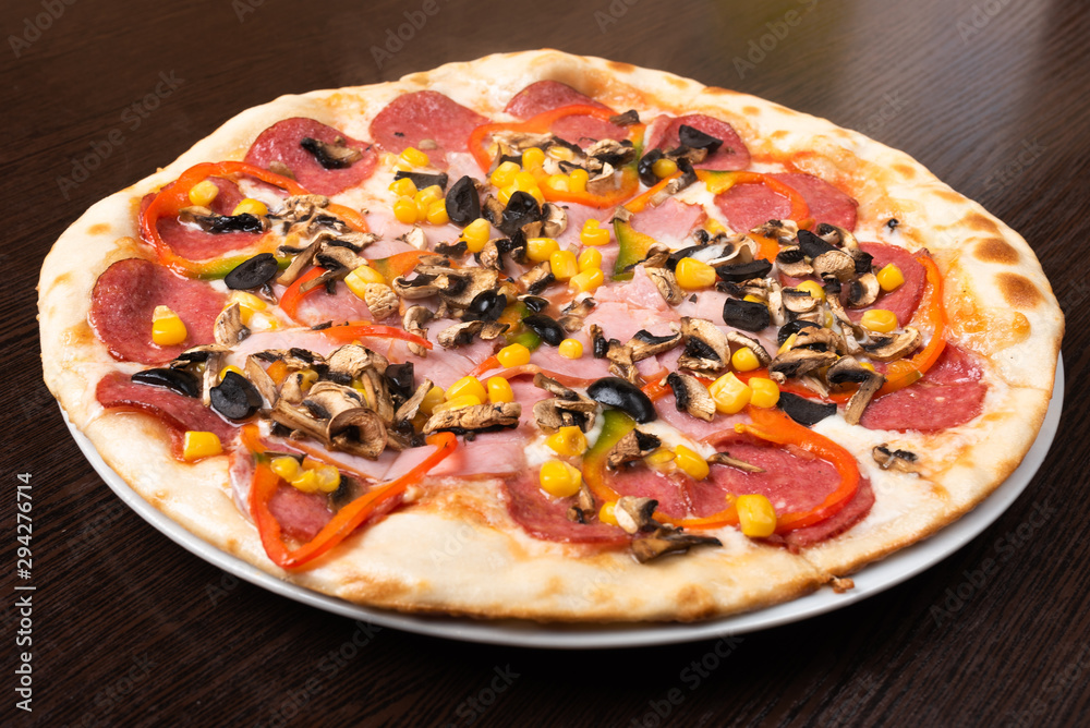 Pizza with pepperoni and mushrooms, ham and sweet pepper. Close-up. Pizza with pepperoni and mushrooms, ham and sweet pepper. Close-up.