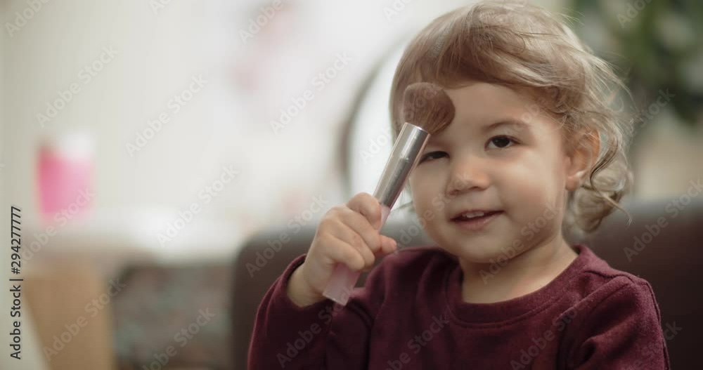 Cute baby girl playing with mom's makeup brushes. Shot in 4K RAW on a cinema camera. Cute baby girl playing with mom's makeup brushes. Shot in 4K RAW on a cinema camera.