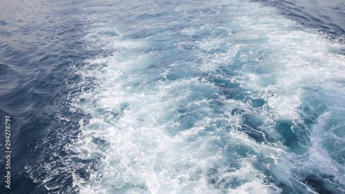 Foamy waves view from the back of moving boat sailing in the ocean.