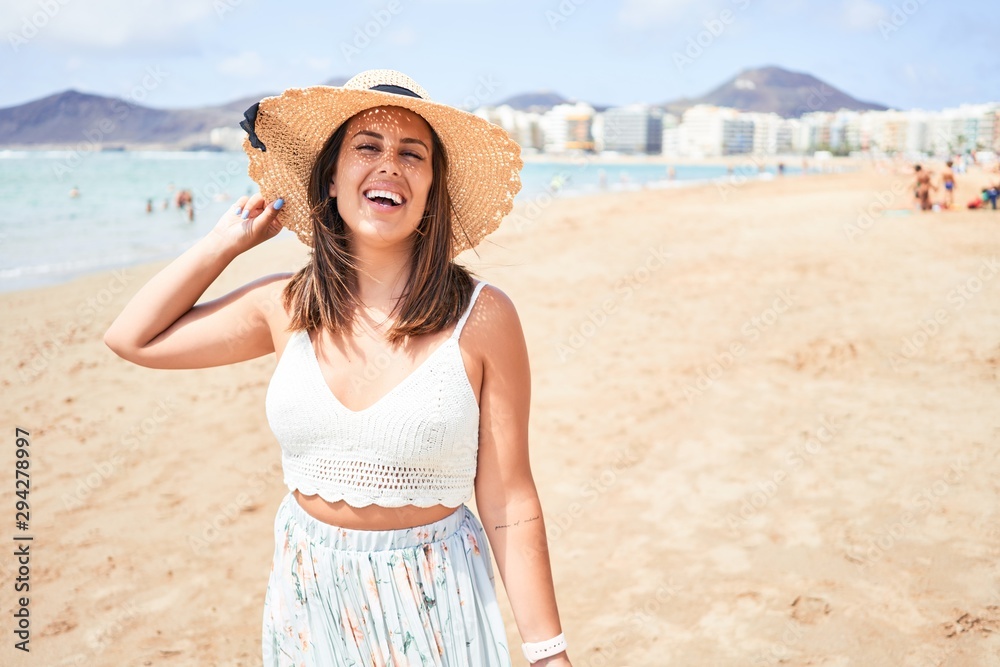 Young beautiful woman smiling happy enjoying summer vacation at the beach