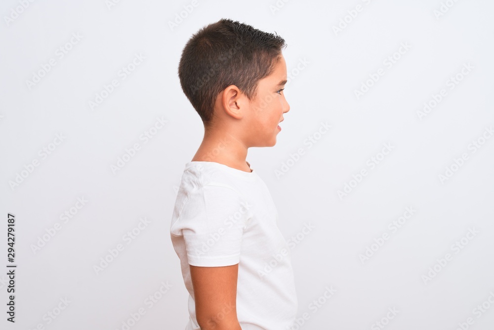 Beautiful kid boy wearing casual t-shirt standing over isolated white background looking to side, relax profile pose with natural face with confident smile. Beautiful kid boy wearing casual t-shirt standing over isolated white background looking to side, relax profile pose with natural face with confident smile.