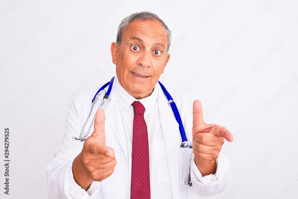 Senior grey-haired doctor man wearing stethoscope standing over isolated white background pointing fingers to camera with happy and funny face. Good energy and vibes. Senior grey-haired doctor man wearing stethoscope standing over isolated white background pointing fingers to camera with happy and funny face. Good energy and vibes.