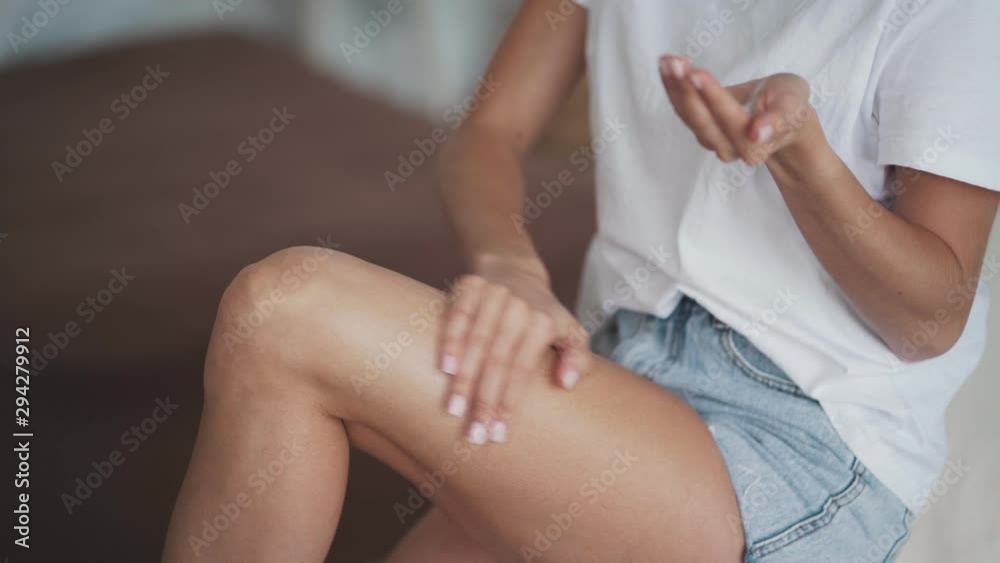 Close up of woman hands applie anti-cellulite cream on her leg Close up of woman hands applie anti-cellulite cream on her leg
