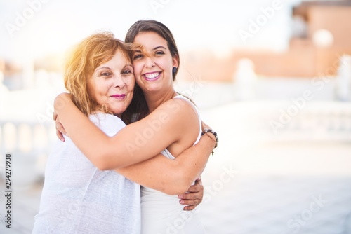 Beautiful mother and daugther hugging at terrace with happy face