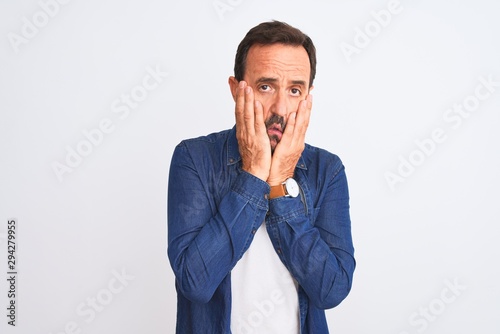 Middle age handsome man wearing blue denim shirt standing over isolated white background Tired hands covering face, depression and sadness, upset and irritated for problem