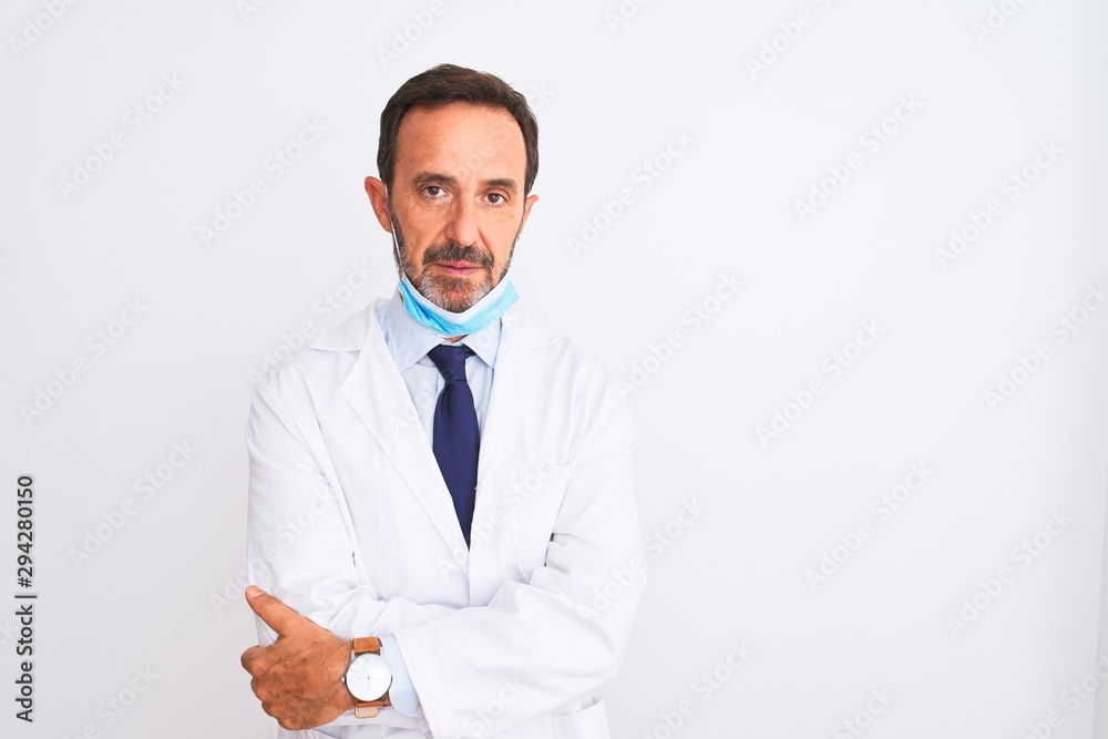 Middle age scientist man wearing coat and medical mask over isolated white background with serious expression on face. Simple and natural looking at the camera. Middle age scientist man wearing coat and medical mask over isolated white background with serious expression on face. Simple and natural looking at the camera.
