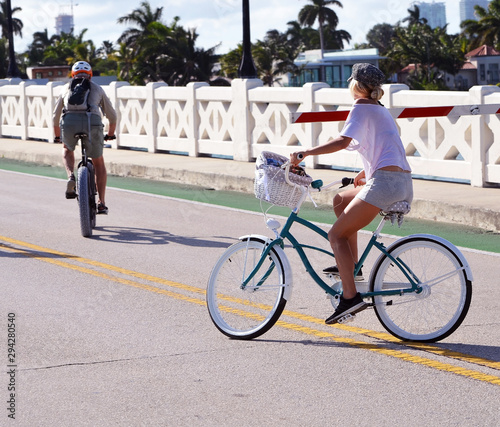 Very attractive lady riding her bicycle across the Venetia Causeway in Miami Beach,Florida