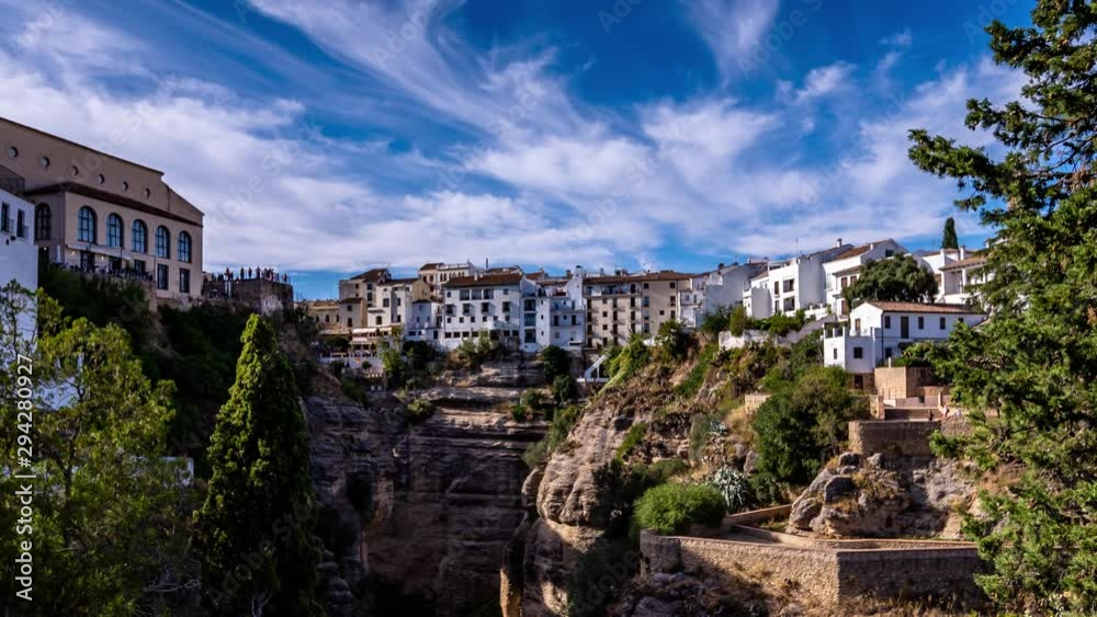 4k time lapse of ronda white spanish houses built on cliff edge, beautiful scenic view and blue sky with moving clouds