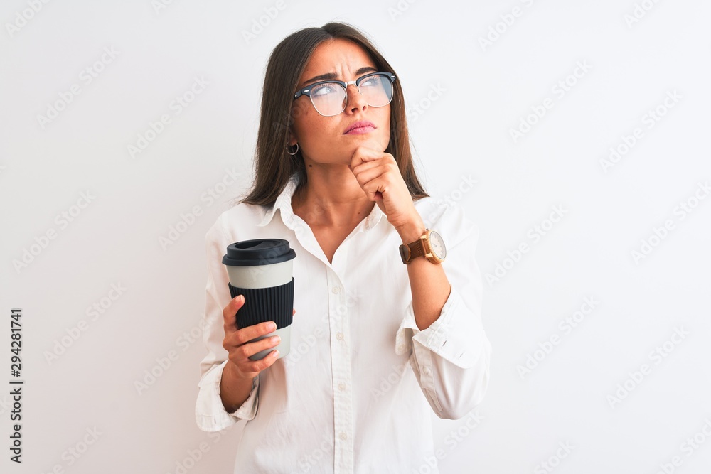 Young businesswoman wearing glasses drinking coffee over isolated white background serious face thinking about question, very confused idea Young businesswoman wearing glasses drinking coffee over isolated white background serious face thinking about question, very confused idea