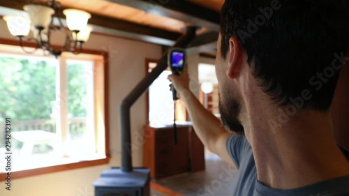 Indoor damp & air quality (IAQ) testing. Slow motion footage of a domestic building surveyor using a handheld infra red thermal imaging camera during an indoor environmental quality (IEQ) assessment.