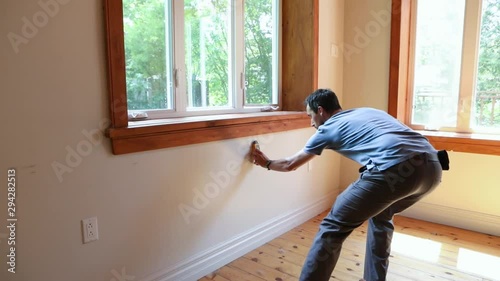 Indoor damp & air quality (IAQ) testing. A slow motion clip of a building inspector using a digital moisture detector around the walls of a family room during a residential living quality assessment.