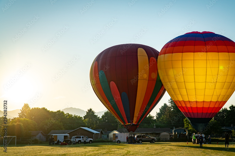 Obraz premium Colorful hot air balloons getting ready to lift off in Grants Pass Oregon on a beautiful summer morning