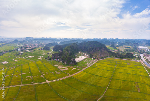 Aerial view of Ninh Binh region, Trang An Tam Coc tourist attraction, UNESCO World Heritage Site, Scenic river crawling through karst mountain ranges in Vietnam, travel destination.