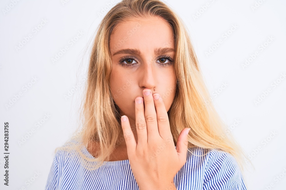 Young beautiful woman wearing elegant blue t-shirt standing over isolated white background cover mouth with hand shocked with shame for mistake, expression of fear, scared in silence, secret concept Young beautiful woman wearing elegant blue t-shirt standing over isolated white background cover mouth with hand shocked with shame for mistake, expression of fear, scared in silence, secret concept