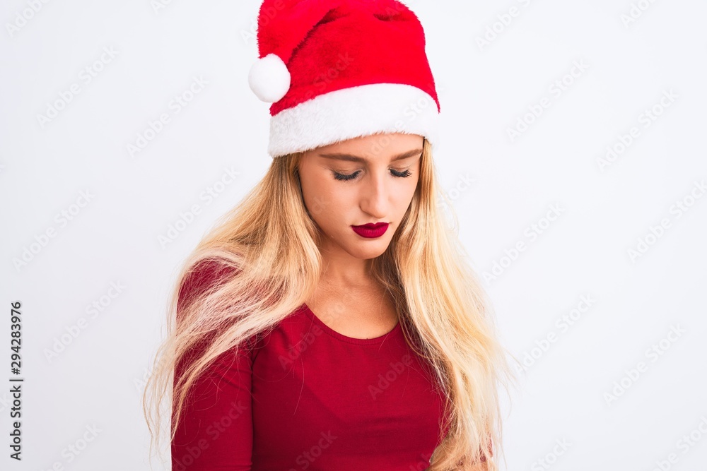 Young beautiful woman wearing Christmas Santa hat over isolated white background with hand on stomach because nausea, painful disease feeling unwell. Ache concept. Young beautiful woman wearing Christmas Santa hat over isolated white background with hand on stomach because nausea, painful disease feeling unwell. Ache concept.