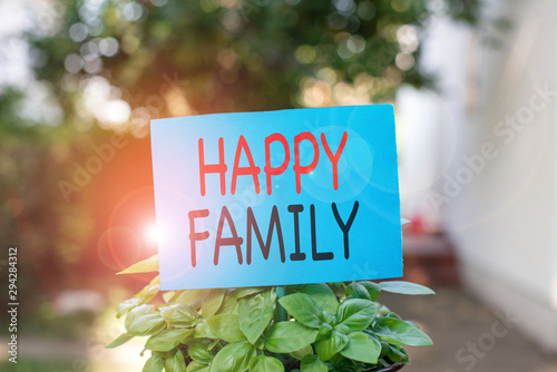 Writing note showing Happy Family. Business concept for family members staying together spending quality time Plain paper attached to stick and placed in the grassy land photo