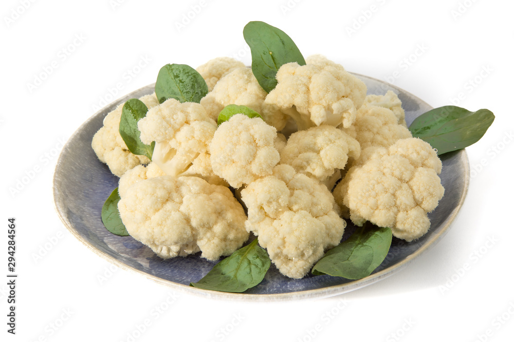 Raw uncooked cauliflower on a plate isolated on white Raw uncooked cauliflower on a plate isolated on white