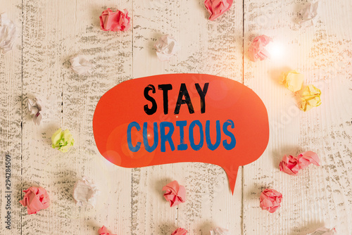 Conceptual hand writing showing Stay Curious. Concept meaning attention through being inexplicable or highly unusual Colored speech bubble paper balls wooden rustic vintage background