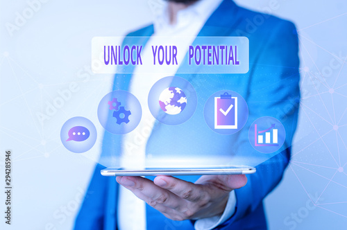 Conceptual hand writing showing Unlock Your Potential. Concept meaning improve self awareness Skills to Achieve more Male human wear formal suit presenting using smart device photo