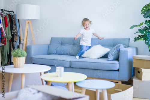 Beautiful toddler child girl jumping on the sofa