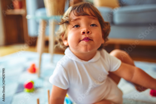 Beautiful toddler child girl playing with toys on the carpet