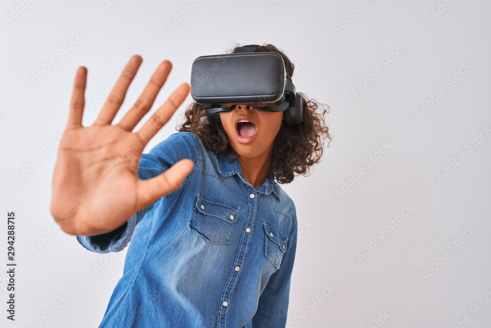 Young african american teenager girl playing virtual reality game using goggles Young african american teenager girl playing virtual reality game using goggles