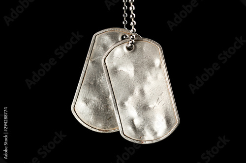 Old and worn blank military dog tags isolated on black