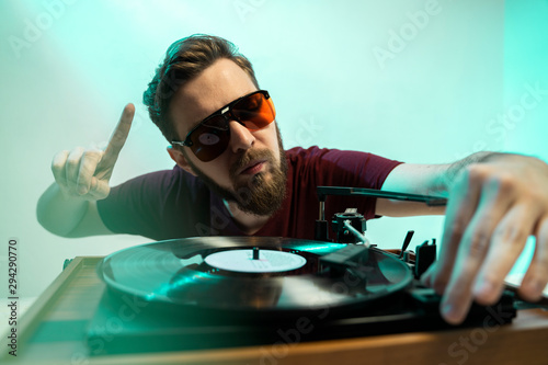 Retro DJ man playing music on record player, retro turntable 