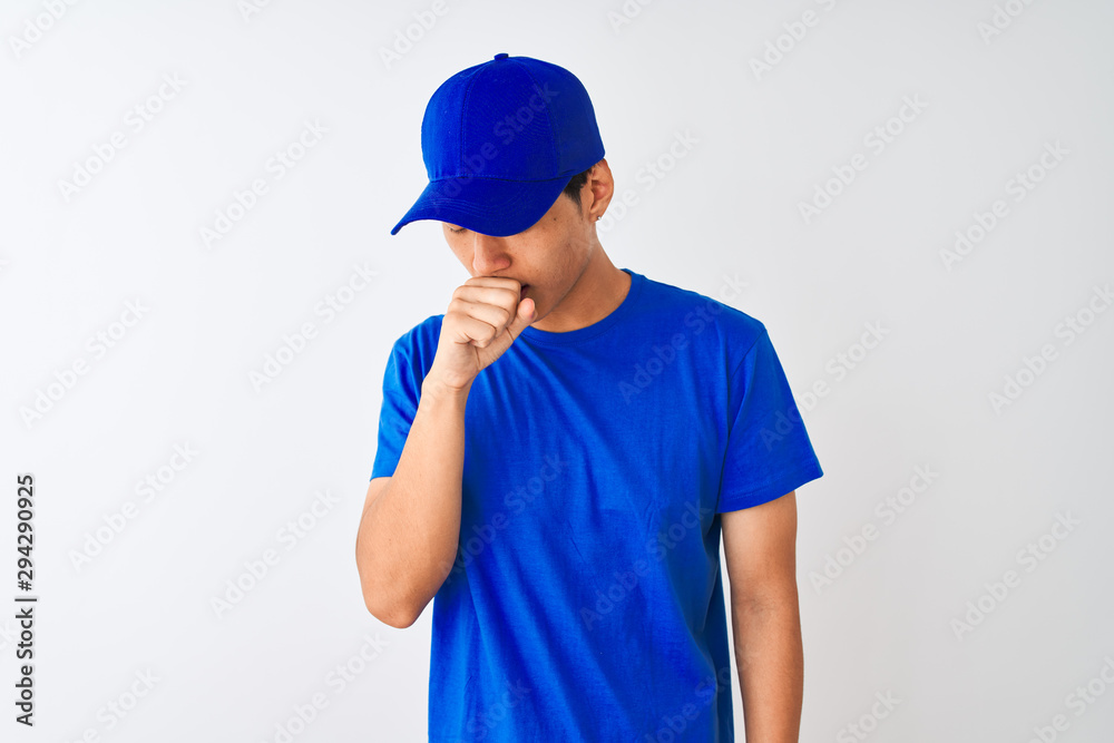 Chinese deliveryman wearing blue t-shirt and cap standing over isolated white background feeling unwell and coughing as symptom for cold or bronchitis. Healthcare concept. Chinese deliveryman wearing blue t-shirt and cap standing over isolated white background feeling unwell and coughing as symptom for cold or bronchitis. Healthcare concept.