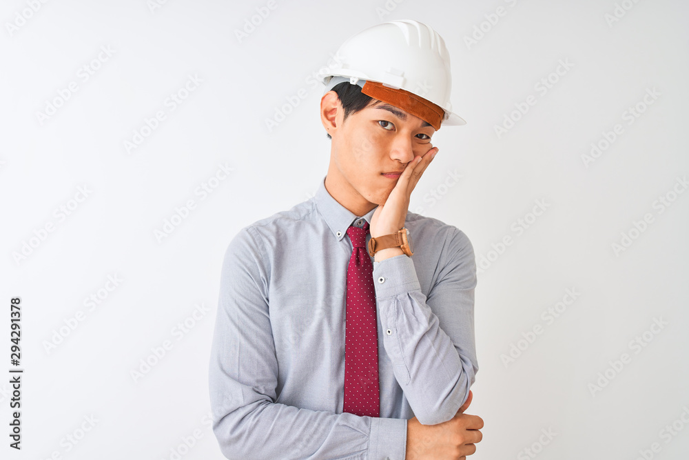 Chinese architect man wearing tie and helmet standing over isolated white background thinking looking tired and bored with depression problems with crossed arms. Chinese architect man wearing tie and helmet standing over isolated white background thinking looking tired and bored with depression problems with crossed arms.