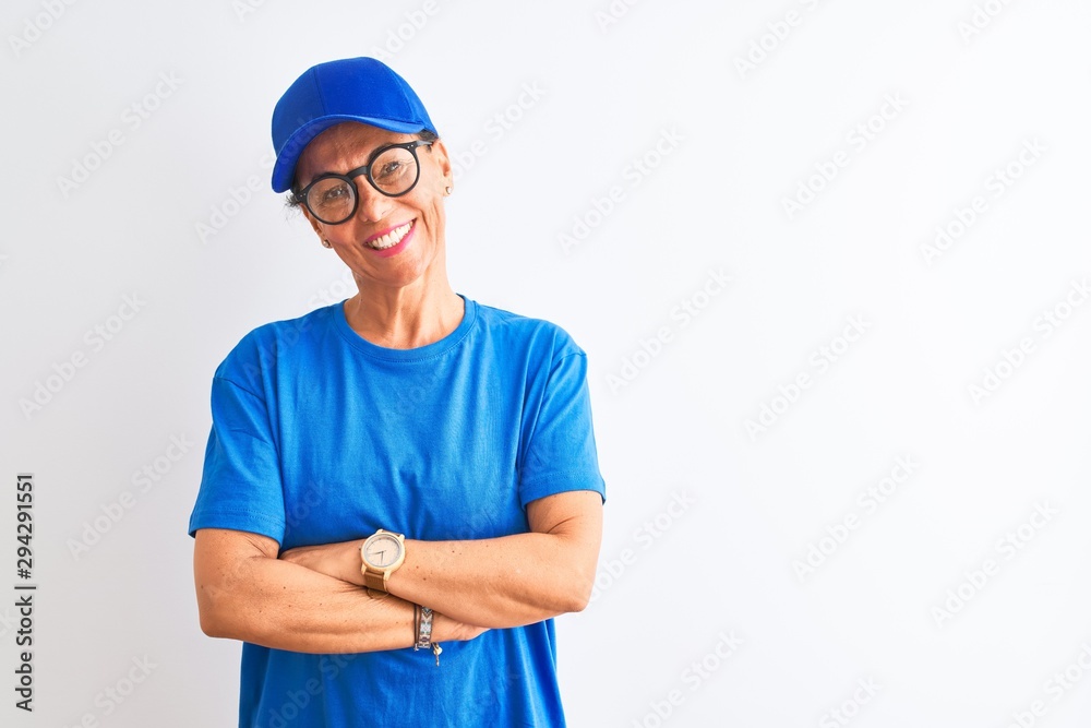 Senior deliverywoman wearing cap and glasses standing over isolated white background happy face smiling with crossed arms looking at the camera. Positive person.