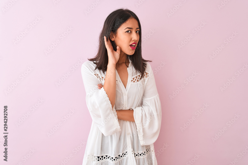Young chinese woman wearing summer shirt standing over isolated pink background smiling with hand over ear listening an hearing to rumor or gossip. Deafness concept. Young chinese woman wearing summer shirt standing over isolated pink background smiling with hand over ear listening an hearing to rumor or gossip. Deafness concept.