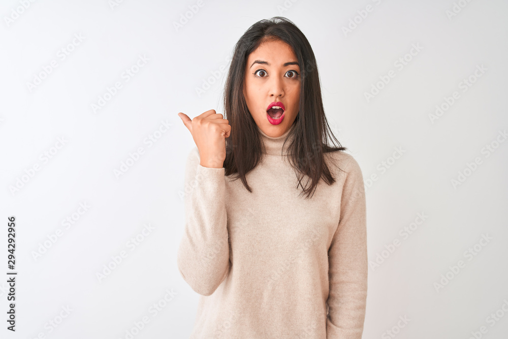 Φωτογραφία Beautiful chinese woman wearing turtleneck sweater standing over isolated white background Surprised pointing with hand finger to the side, open mouth amazed expression